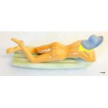 A porcelain figurine of a sunbathing naked lady