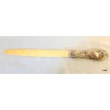 A Victorian hallmarked silver handled bone page turner with highly ornate repousse floral scroll and