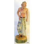 An Oriental carved wood figure of a man hand painted 20cm high