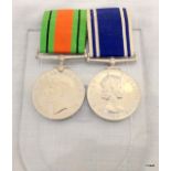 A WW2 Defence Medal with a Police Long Service & Good Conduct Medal mounted on a pocket display