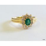 An 18ct gold diamond and emerald cluster ring size K/L