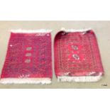 A pair of red pattered small hall carpets 75 x 52