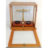 A set of late Victorian precision scales in a light oak glazed case by Eureka - London