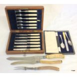 A bone handled carving set with a set of cake knives and forks and a silver christening set