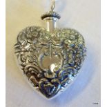 A silver heart shaped perfume bottle