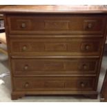 A dark wood four drawer chest of drawers