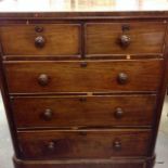 A Victorian chest of drawers on bun feet.