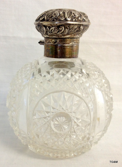 A silver scent bottle and stopper cut glass