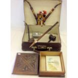 A vintage suitcase containing a carved wooden box and other collectables including Bavarian Pipes