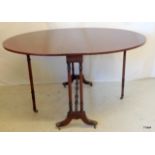 A mahogany Southerland table on brass casters an oval shape on turned supports 74 height  x 100