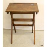 A vintage folding school desk with recessed inkwell