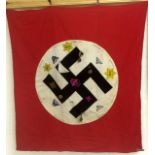 A genuine WW2 Nazi flag bearing the Swastika, surrounded by various patches & medals, the property