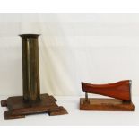 A trench art shell case vase 34cms high mounted on a wooden base with a rifle stock presentation