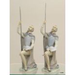 A pair of Lladro figures of jousting knights with metal lances. Measuring 27cm tall.