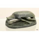 An Egyptian stone carved scarab beetle with marks to the base. 14 x 9cm