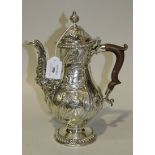 A George III silver coffee pot, the baluster body decorated in relief with rococo scrolls, leaves