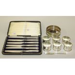 A set of six George V silver napkin rings with scroll rims, Birmingham 1914, a set of six silver