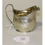 A George III silver cream jug of oval form with ribbon and reeded handle and reeded rim above an