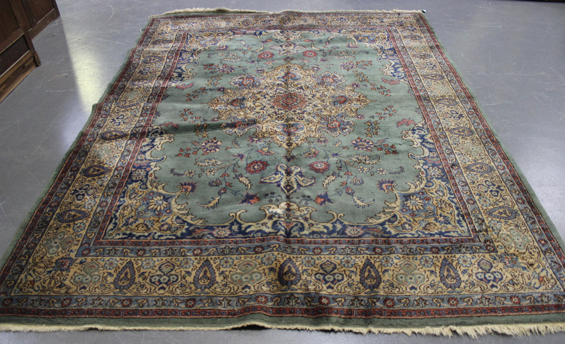 An Indian carpet, mid-20th Century, the green field with a lobed medallion, within an ivory palmette