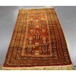 An Afghan rug, mid-20th Century, the tangerine field with overall stylized birds, animals and