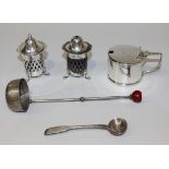 A pair of George V silver salt and pepper casters with pierced lattice decoration, on scroll legs,