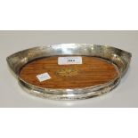 A George V silver oval boat shaped coaster, the interior rim engraved with a floral garland, the