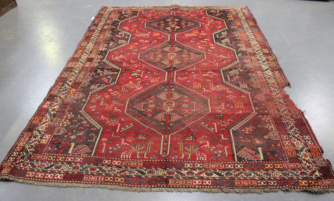 A Shiraz carpet, South-west Persia, early 20th Century, the red field with three linked medallions