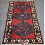 A Hamadan rug, North-west Persia, mid-20th Century, the red field with three stepped reserves,