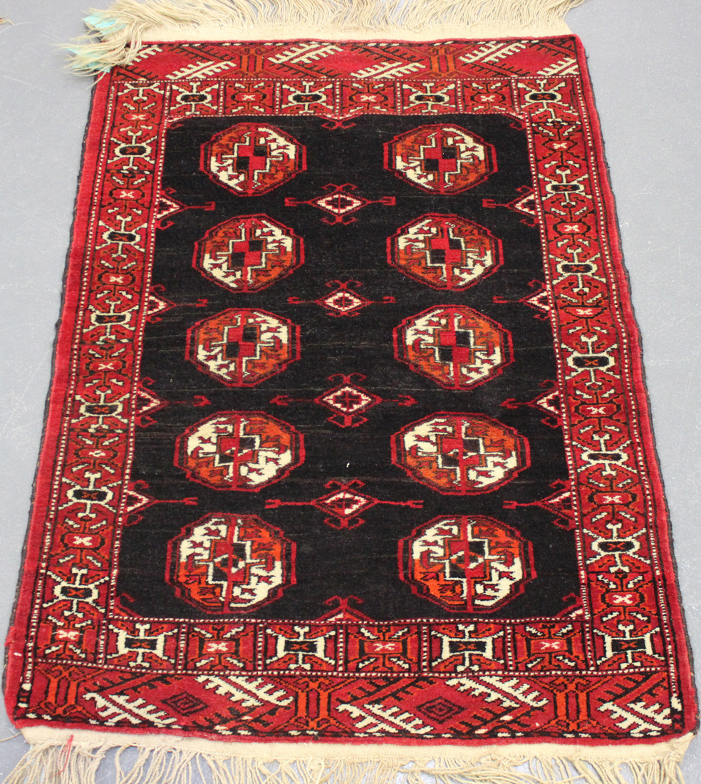 A Turkoman rug, early 20th Century, the plum field with two columns of six guls, within an ivory - Image 3 of 4