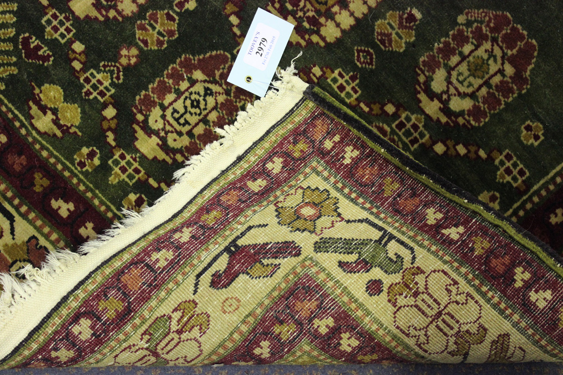 A Persian rug, late 20th Century, the green field with two hooked medallions supported by floral - Image 2 of 2