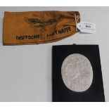 A yellow Deutsche Luftwaffe armband, together with an oval plaster plaque, designed by a First World