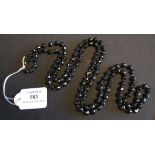 A long single row necklace of faceted black glass beads, together with two other faceted black glass