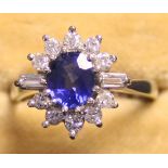 An 18ct white gold, sapphire and diamond oval cluster ring, claw set with the oval cut sapphire in a