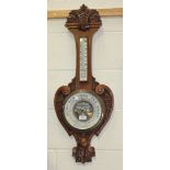 An Edwardian walnut cased wheel aneroid barometer, with ceramic dials and mercury thermometer, the