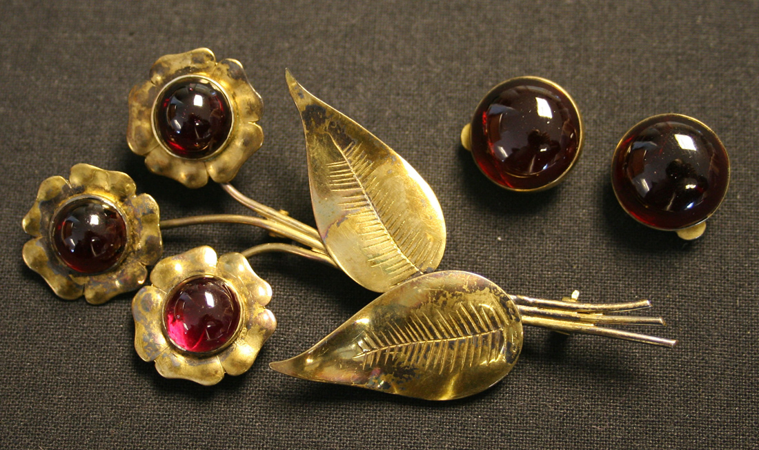 A silver gilt and carbuncle garnet set brooch designed as a floral spray, and a pair of silver