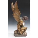An early 20th Century painted plaster model of a kneeling angel with his hands crossed over his