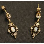 A pair of gold, opal and diamond pendant earrings, each claw set with an oval opal within a