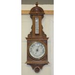 An early 20th Century oak aneroid barometer with ceramic dials and mercury thermometer, the case