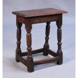 A mid-17th Century oak joint stool, the moulded top above a carved frieze, on turned and block