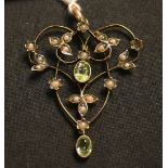 A gold, seed pearl and peridot set pendant in a scroll pierced foliate design, detailed '9ct',