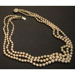 A three row necklace of graduated cultured pearls, on a gold and cultured pearl snap clasp, length