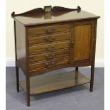 An Edwardian walnut music chest, fitted with five drawers flanked by a cabinet, on square tapering