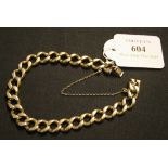 A 9ct gold faceted curblink bracelet on a snap clasp with a safety chain.