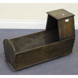 A late 19th/early 20th Century oak doll's hooded cradle, length approx 68cm.