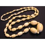 A single row necklace of graduated oval ivory beads alternating with smaller beads.