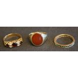 A 9ct gold, garnet and colourless gem set ring, a 9ct gold and cornelian set oval signet ring, and a
