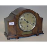 An Art Deco walnut cased mantel clock with eight day movement chiming on gongs, the back plate