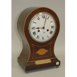 An early 20th Century mahogany balloon cased mantel clock with eight day movement striking on a