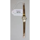 A Tissot 9ct gold lady's bracelet wristwatch, the signed circular silvered dial with baton shaped