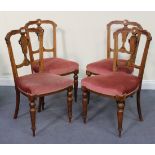 A set of four late Victorian walnut bar and splat back dining chairs, with inlaid decoration, the